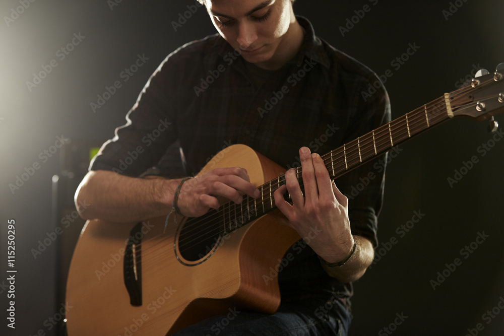 Obraz premium Man Using Tapping Technique On Acoustic Guitar
