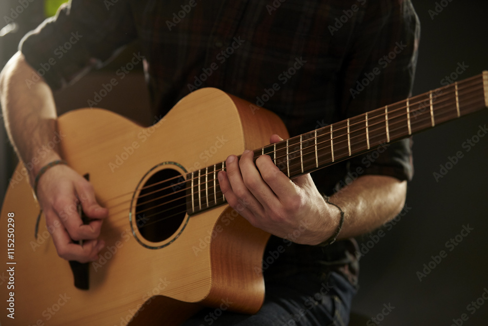 Fototapeta premium Close Up Of Man Playing Acoustic Guitar In Studio