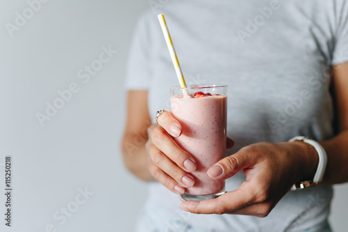 A girl holds a berry smoothie