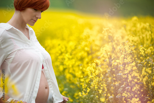 Kobieta w ciąży na plantacji rzepaku