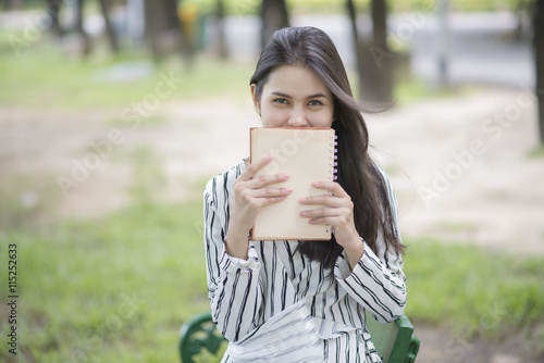 Attractive woman reading a book in the park