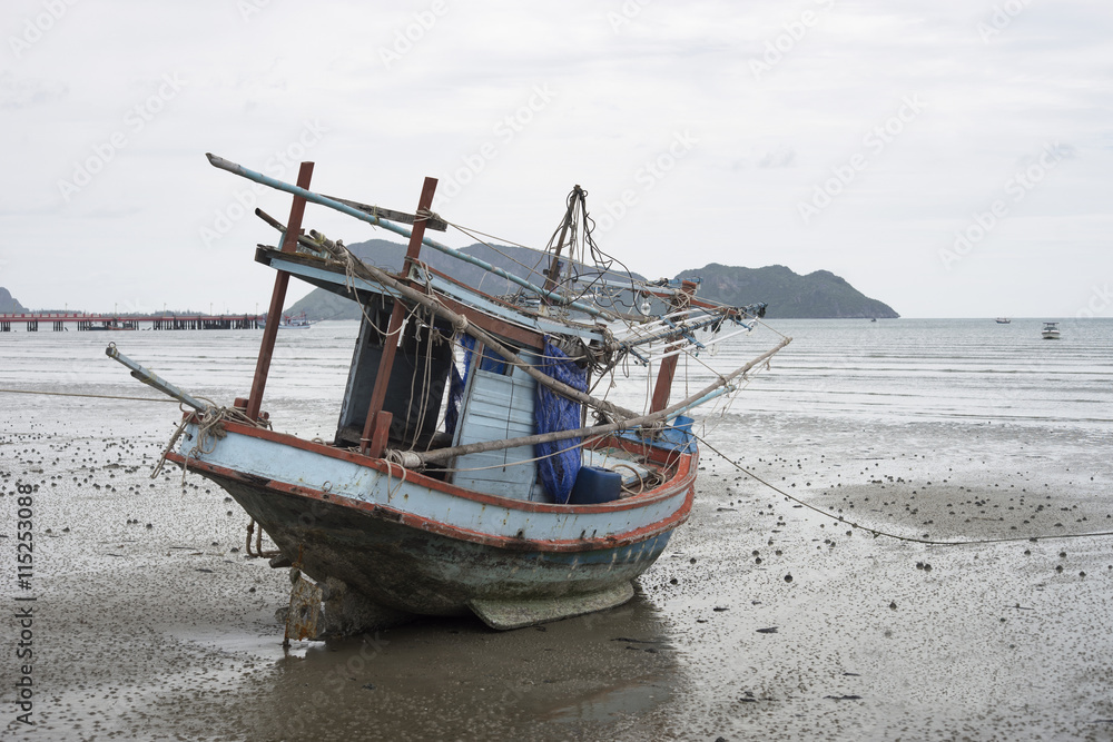 traditional fishing boat laying on a beach near the sea with mountain and island, selective focus,filtered image