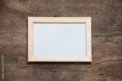 Wooden photo frame on old rustic wooden wall.
