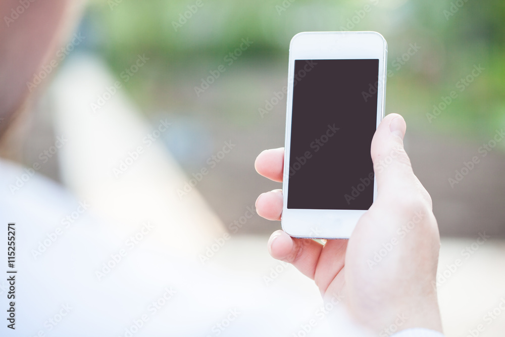 Man showing smart phone with empty black screen. Outdoor. Toned photo.