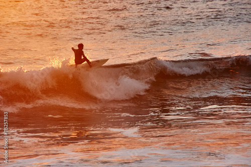 Surfer riding a wavein the waters of the Pacific ocean photo