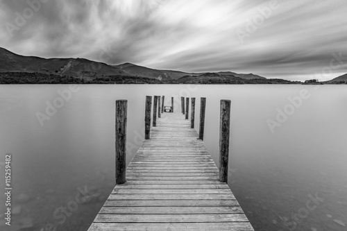 Obraz na plátně Long wooden jetty at Derwentwater Lake with moody dramatic clouds