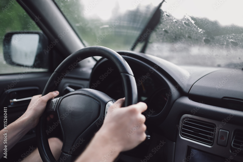 Drive car in rain. Hands on steering wheel Drive car in rain. Hands on steering wheel