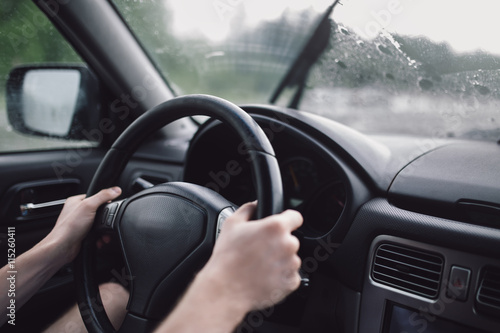 Drive car in rain. Hands on steering wheel