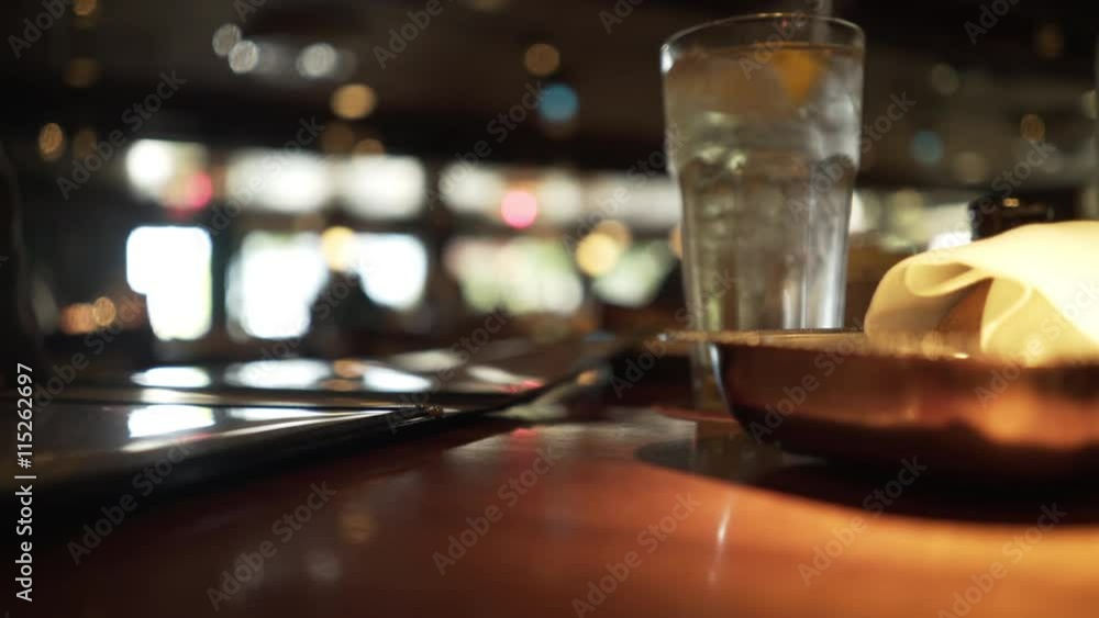 Focus is on objects in the foreground on this restaurant table with out of focus activity in the background. Focus is on objects in the foreground on this restaurant table with out of focus activity in the background.