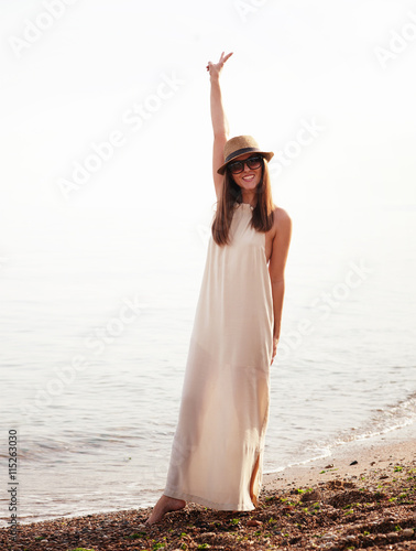 Joyful casual girl walking on a sea beach and happy smiling