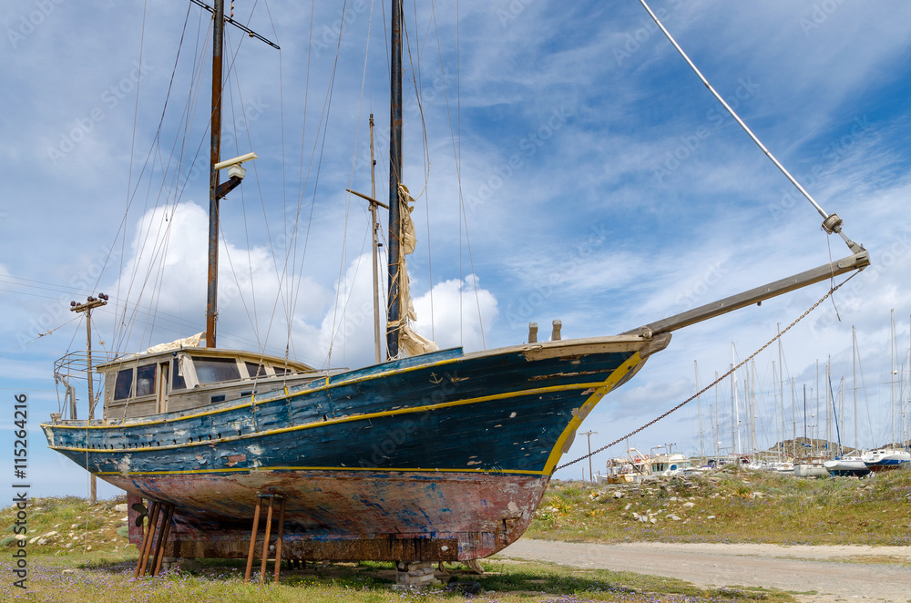 Obraz premium Greek harbor scene. Fishing boats being serviced in a traditional greek village harbor, Paros island, Greece