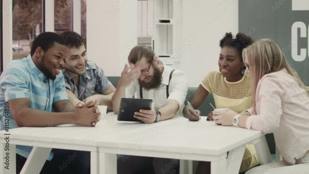 Co-working in office. Colleagues using tablet at table Co-working in office. Colleagues using tablet at table