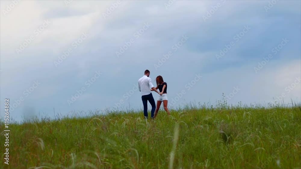 Young couple walking through green field Young couple walking through green field