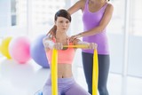 Woman with trainer holding resistance band