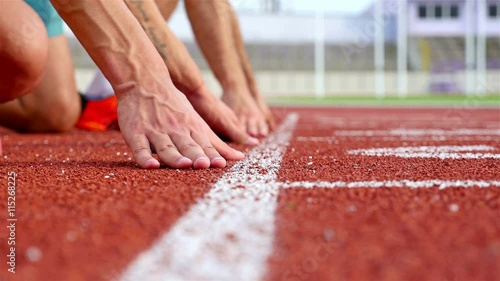 Track runners putting hands at starting line