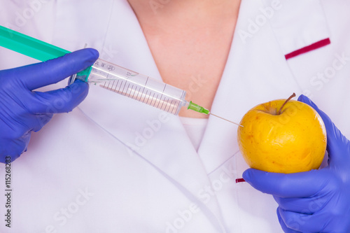 Scientist doctor injecting apple. GM Food.