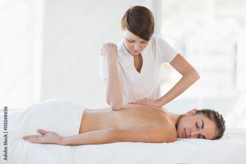 Masseuse giving massage to relaxed woman Masseuse giving massage to relaxed woman