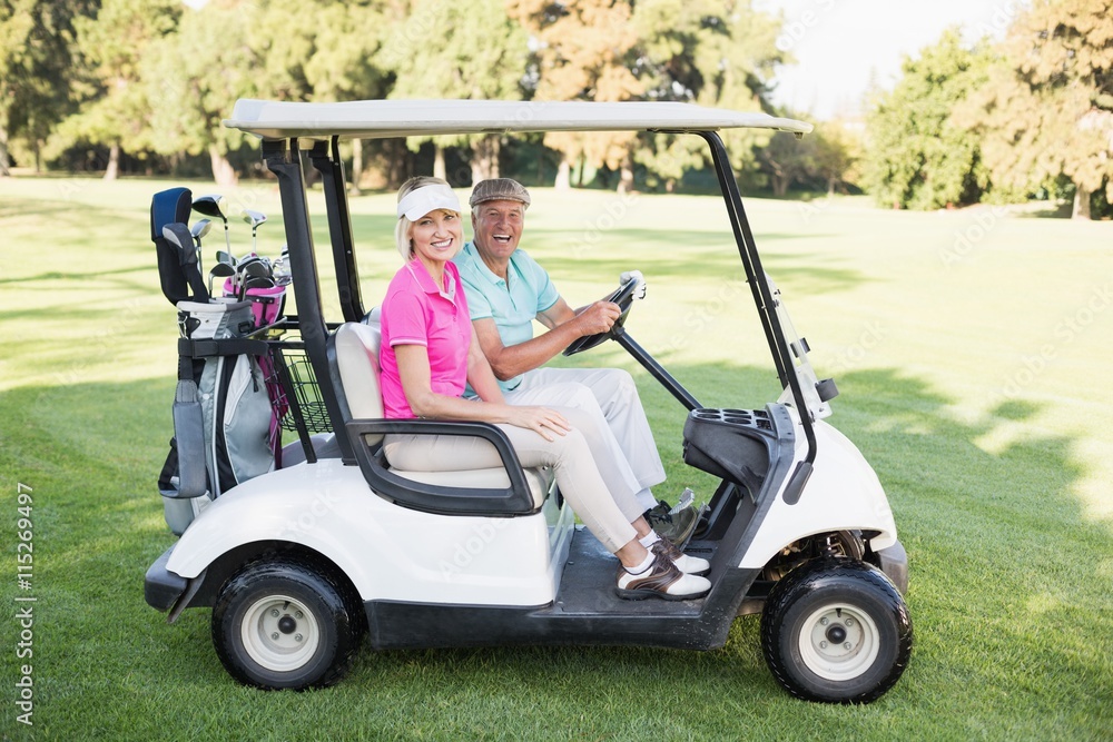 Happy mature couple sitting in golf buggy Happy mature couple sitting in golf buggy