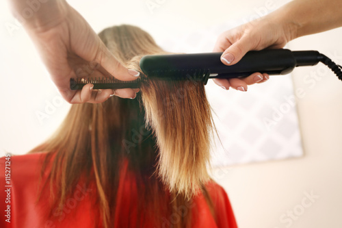 Professional hairdresser straightening hair