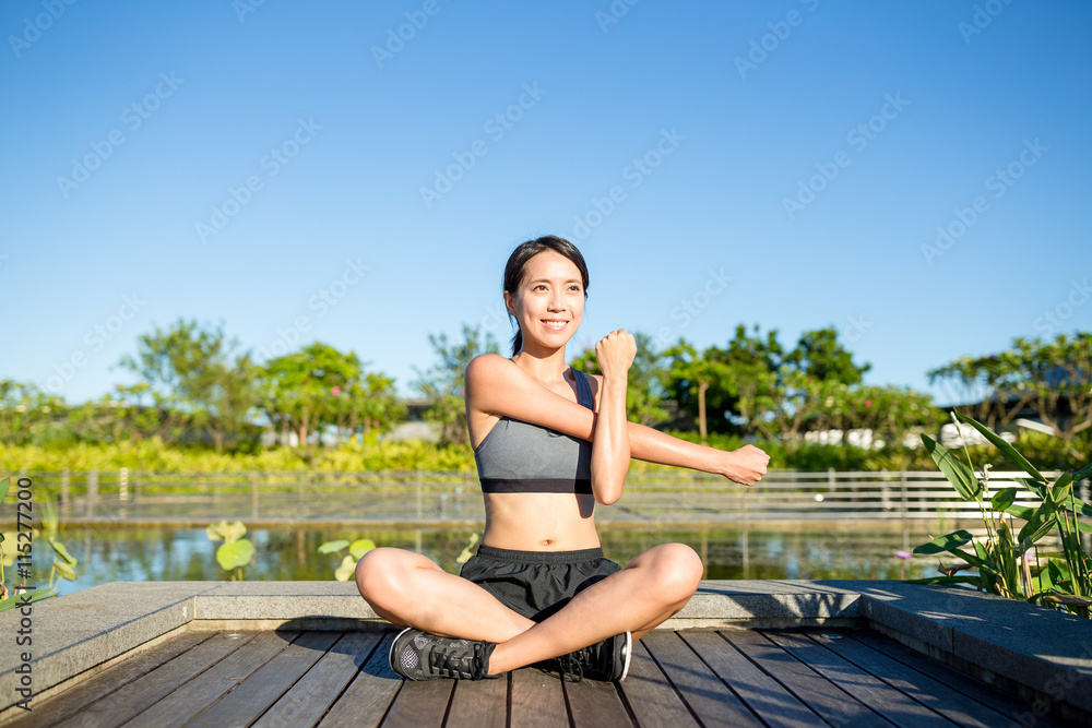 Fit woman stretching er hand at outdoor