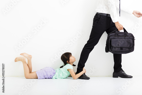 little girl holding her father's legs before go to work