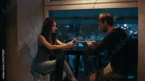 Couple Young Boy and Girl using the phone in cafe photo