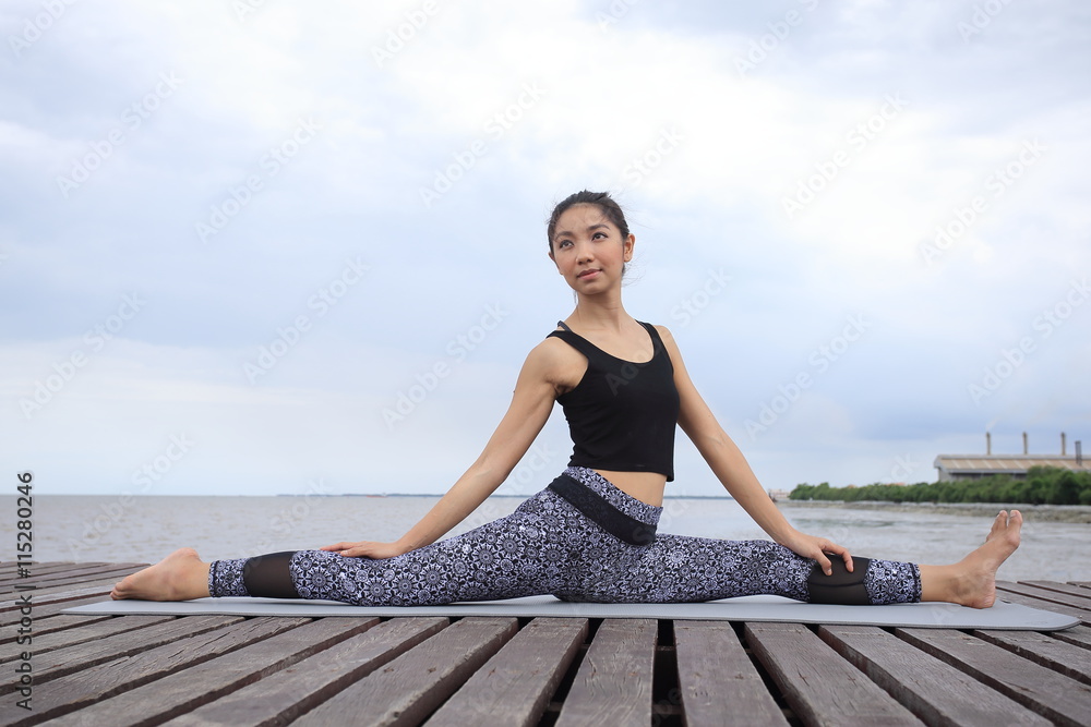 Thai woman professional yoga trainer poses in outdoor location in Thailand.
