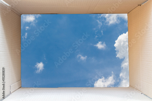 Inside of brown cardboard box with blue sky background