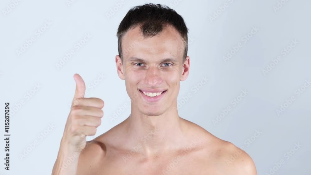Portrait of smiling young topless man with thumb up Portrait of smiling young topless man with thumb up