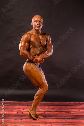 bodybuilder posing over black background