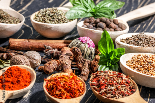 Colorful aromatic spices and herbs on an old wooden backgrownd © ilietus