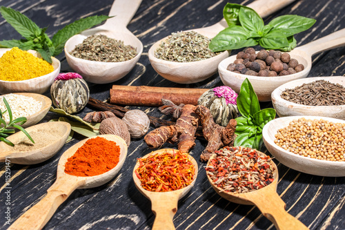 Colorful aromatic spices and herbs on an old wooden backgrownd