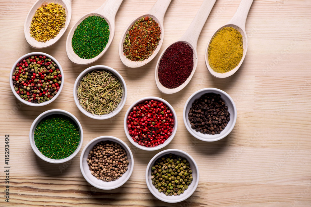Spices in plates and spoons on wooden table Spices in plates and spoons on wooden table