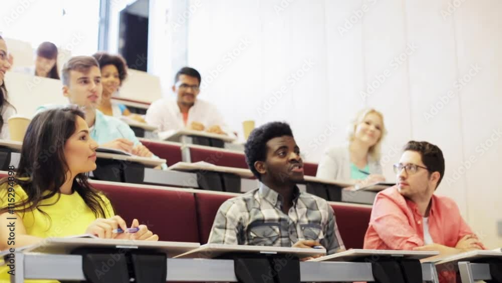 group of students with notebooks in lecture hall group of students with notebooks in lecture hall