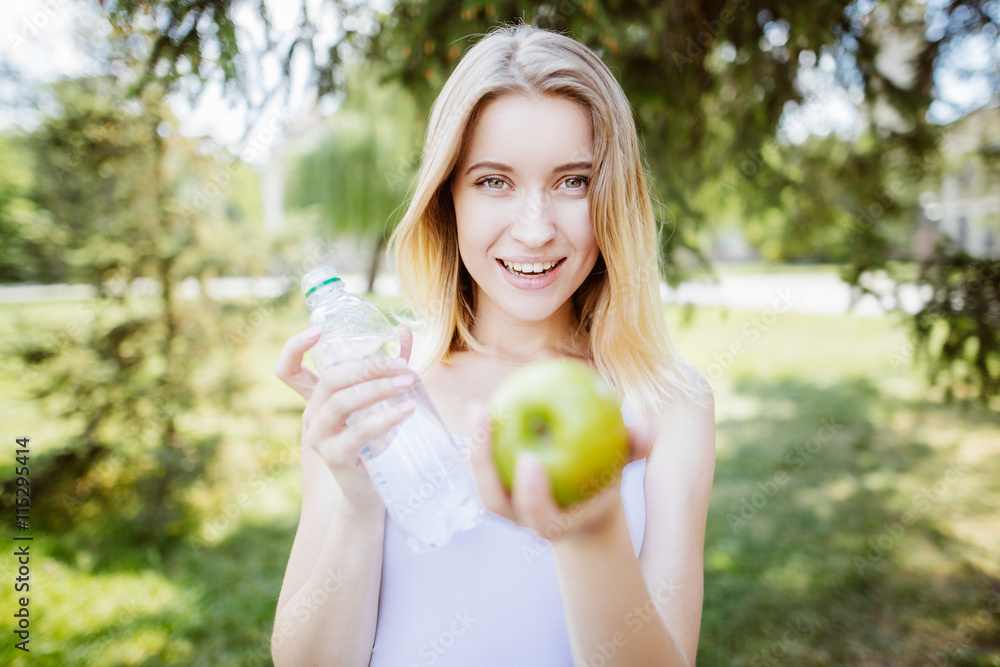 gren apples.smiling woman with apple, outdoors, Healthy eating concept.Close up