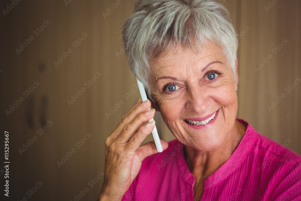 Portrait of a smiling retired woman making a call Portrait of a smiling retired woman making a call
