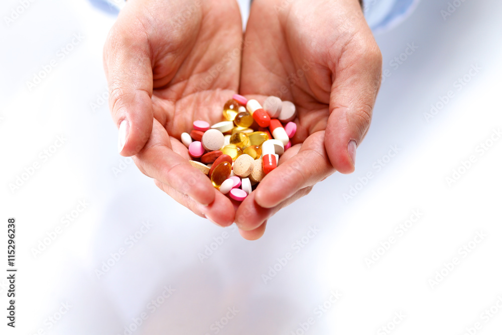 A young doctor holds the patient's hand with pills A young doctor holds the patient's hand with pills