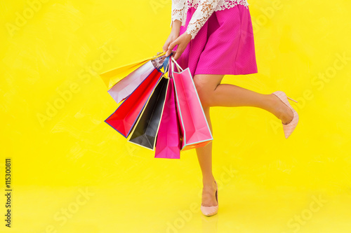 Woman with sexy legs holding shopping bags photo