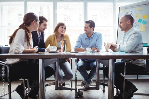 Coworkers discussing in meeting room photo