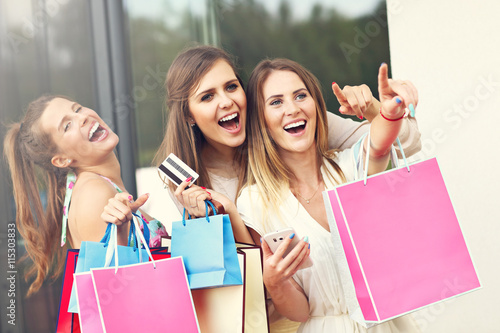 Group of girlfriends shopping in the city with credit card and p