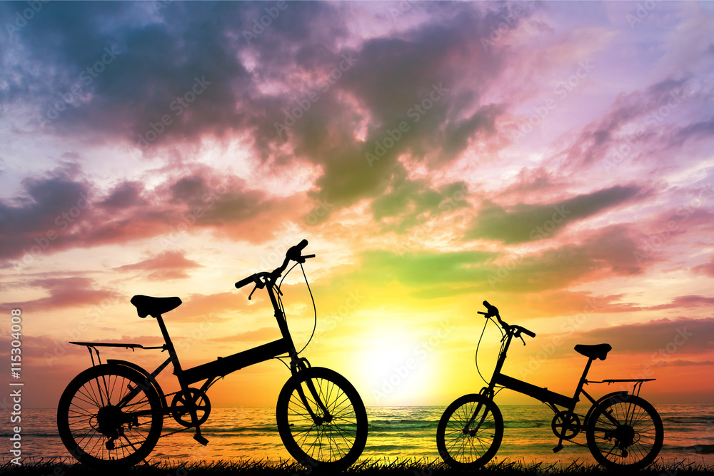 Fototapeta premium Bike silhouette on the grass.Blurred background sunset