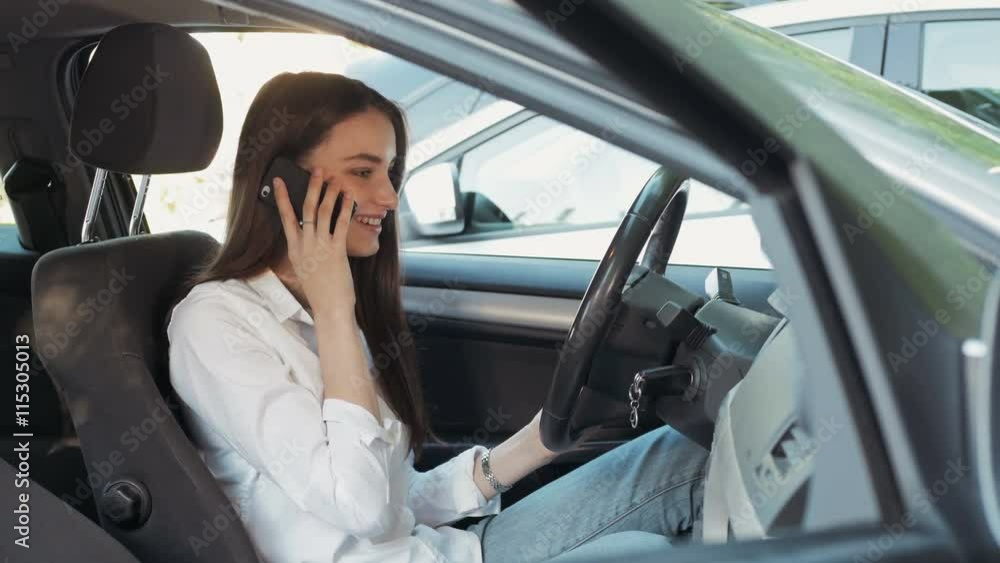 Young Attractive Smiling Woman Sitting In Car And Using Cell Phone Young Attractive Smiling Woman Sitting In Car And Using Cell Phone