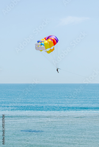 Colored parasail wing in the blue sky, sea water, close up