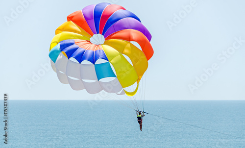 Colored parasail wing in the blue sky, sea water, close up photo