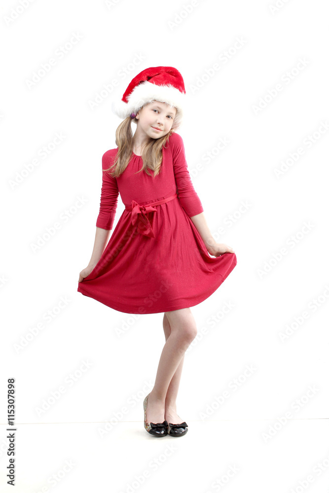 the vertical portrait of standing beautiful smiling little girl wearing on red dress and Santa Claus hat on white background the vertical portrait of standing beautiful smiling little girl wearing on red dress and Santa Claus hat on white background