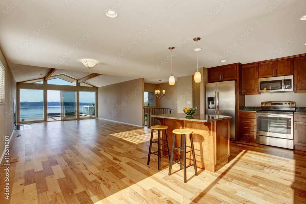 Spacious kitchen interior with hardwood floor and beige walls in luxury house.