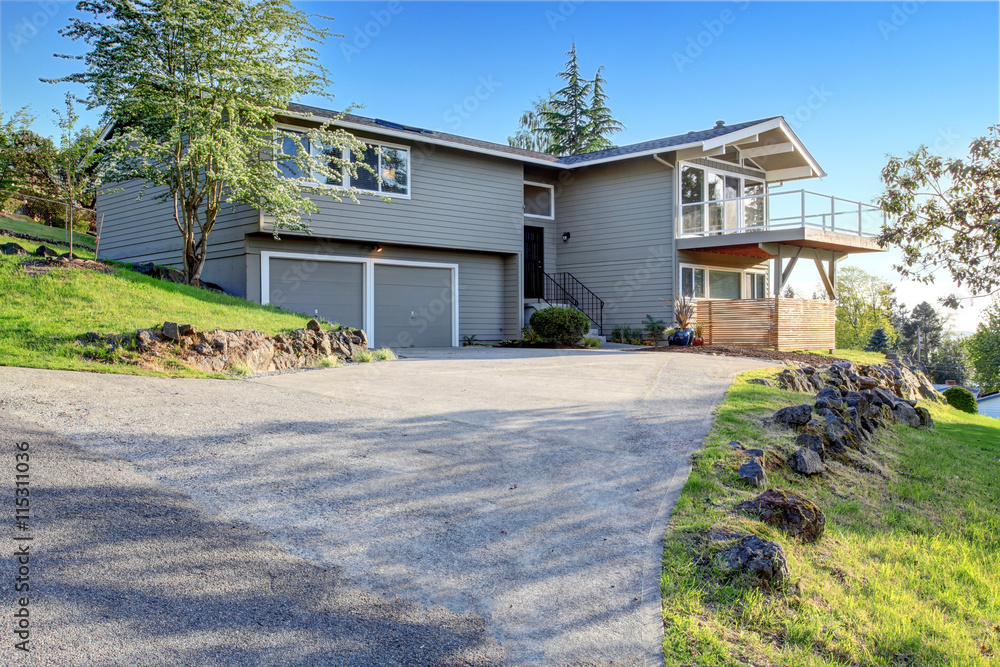 Two story house exterior with gray siding and concrete driveway. Two story house exterior with gray siding and concrete driveway.