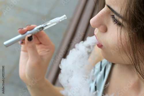 Girl smokes an electronic cigarette