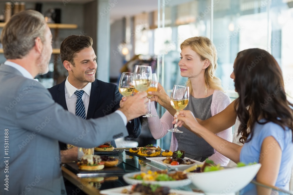 Business colleagues toasting beer glasses while having lunch Business colleagues toasting beer glasses while having lunch