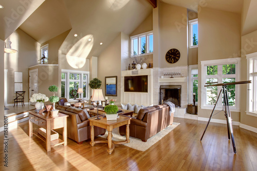 Large living room interior design with high vaulted ceiling and leather sofa set.